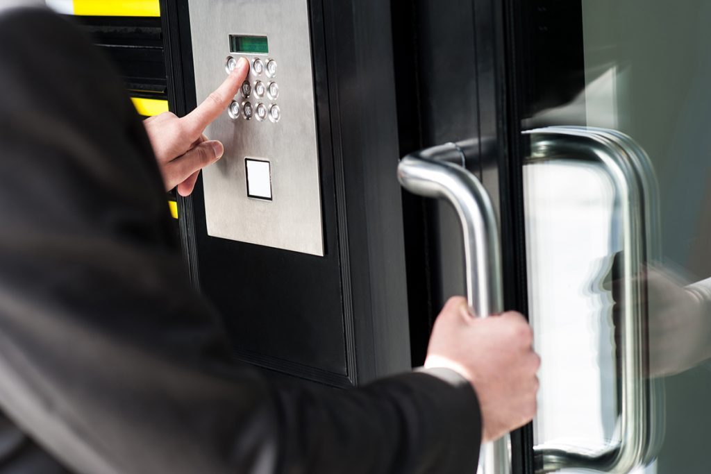 An employee using an access control keypad to enter into the workplace