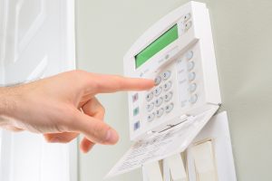 Person presses the buttons on a residential alarm system