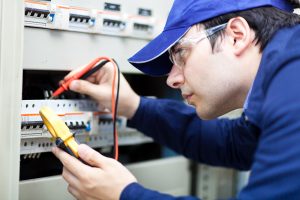 An electrician installs an electrical system at a business